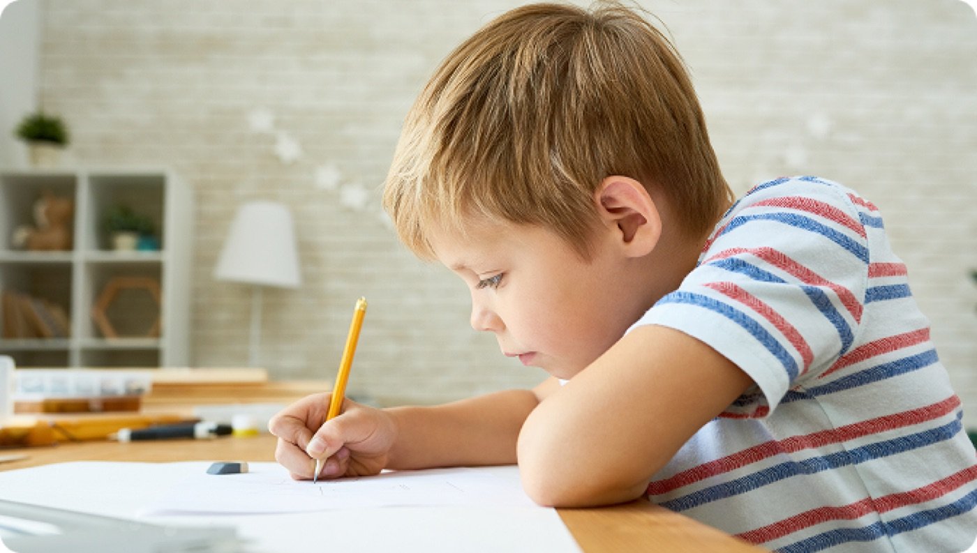 Young boy practicing his writing with a pencil