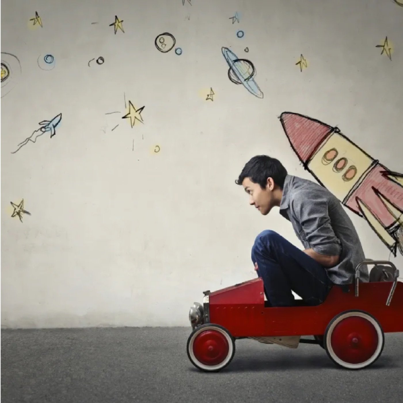 Boy riding a cardboard rocket car