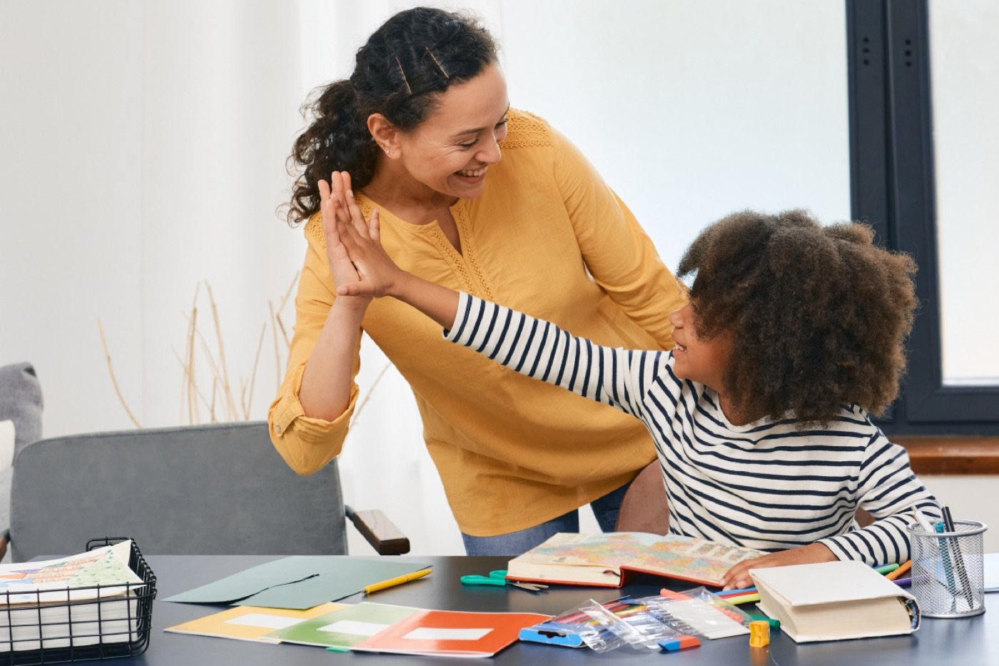 Therapist giving a young child a high five during a session