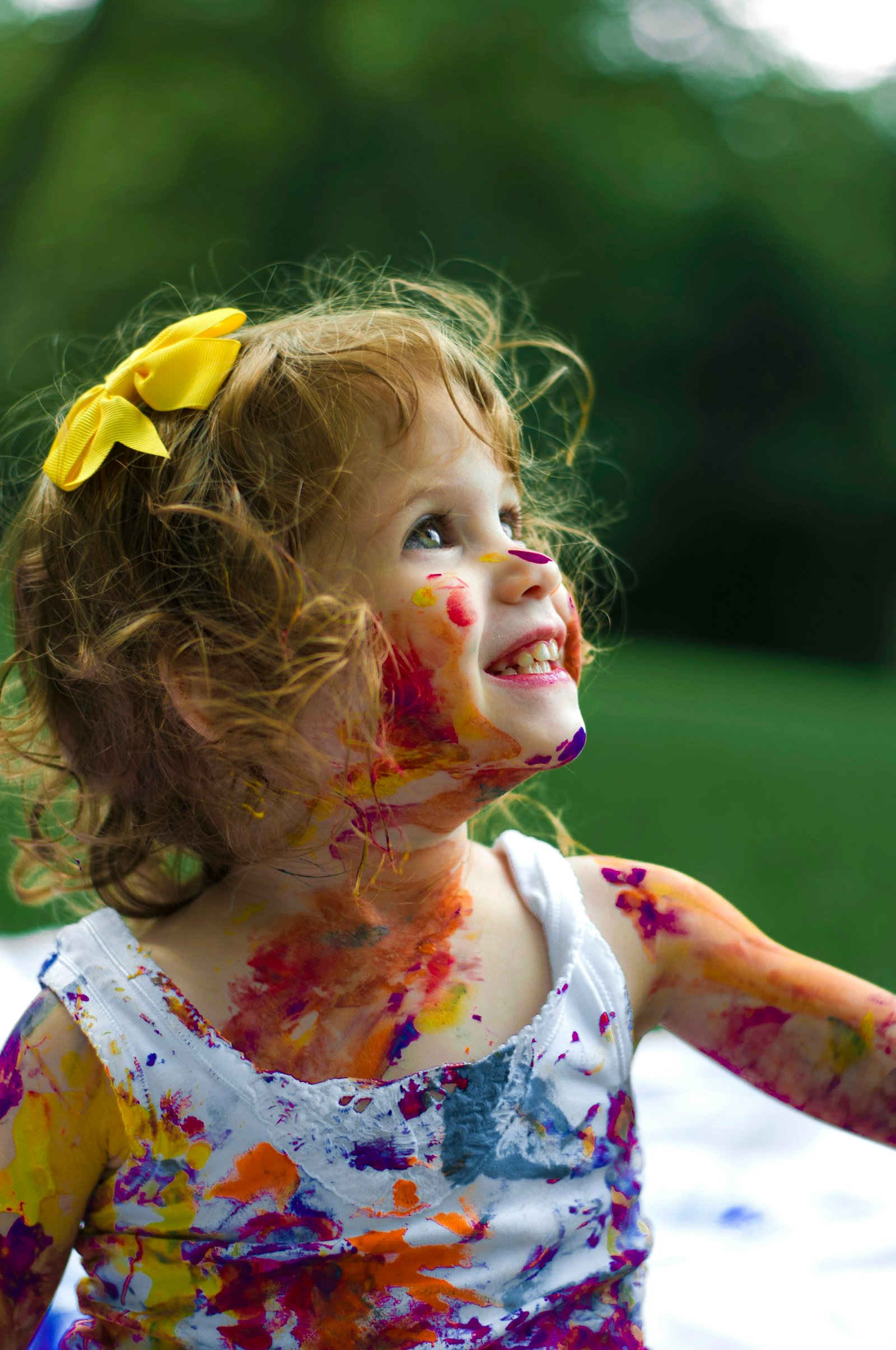 Smiling little girl with colorful paint on her face