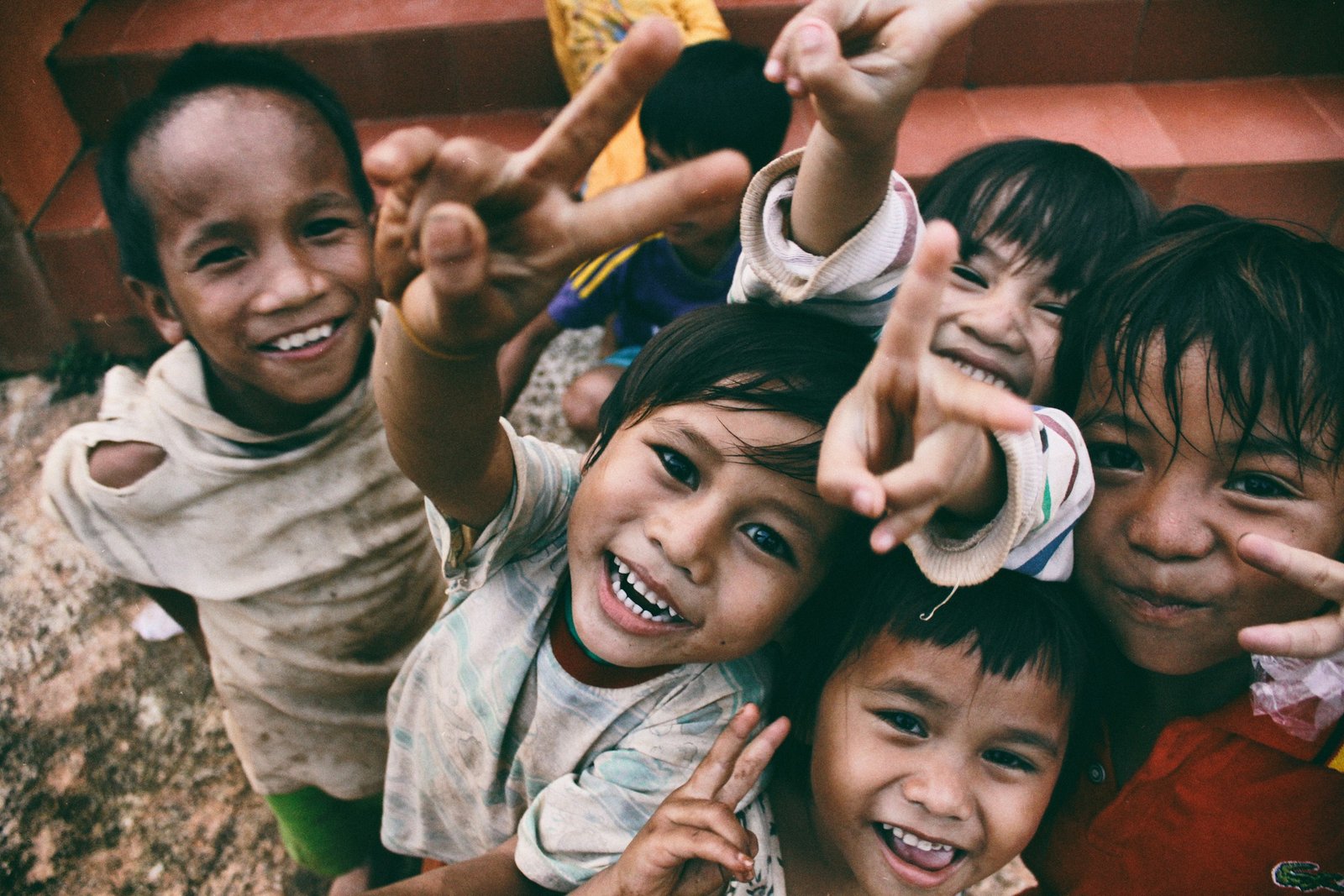 Group of smiling children crowding together toward the camera